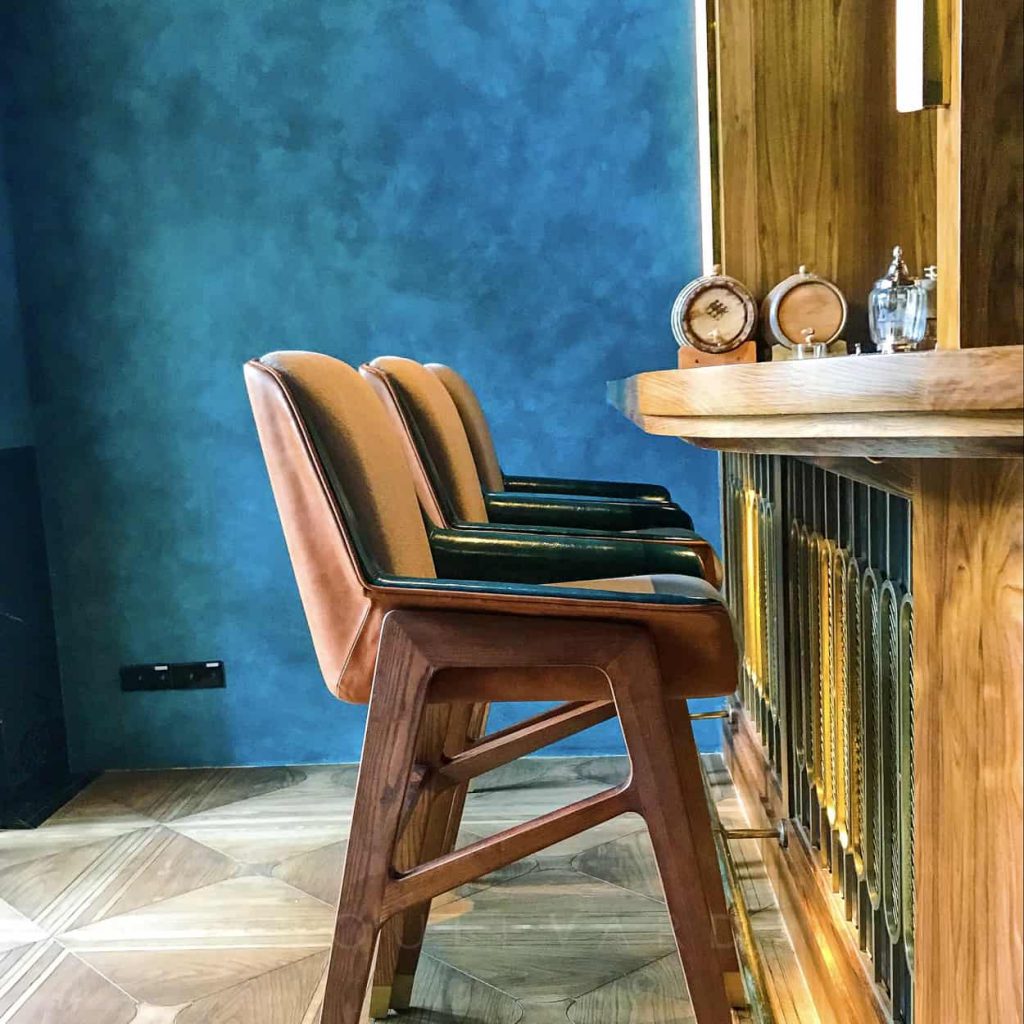 The custom, art-deco inspired bar chairs have a sculptural silhouette.